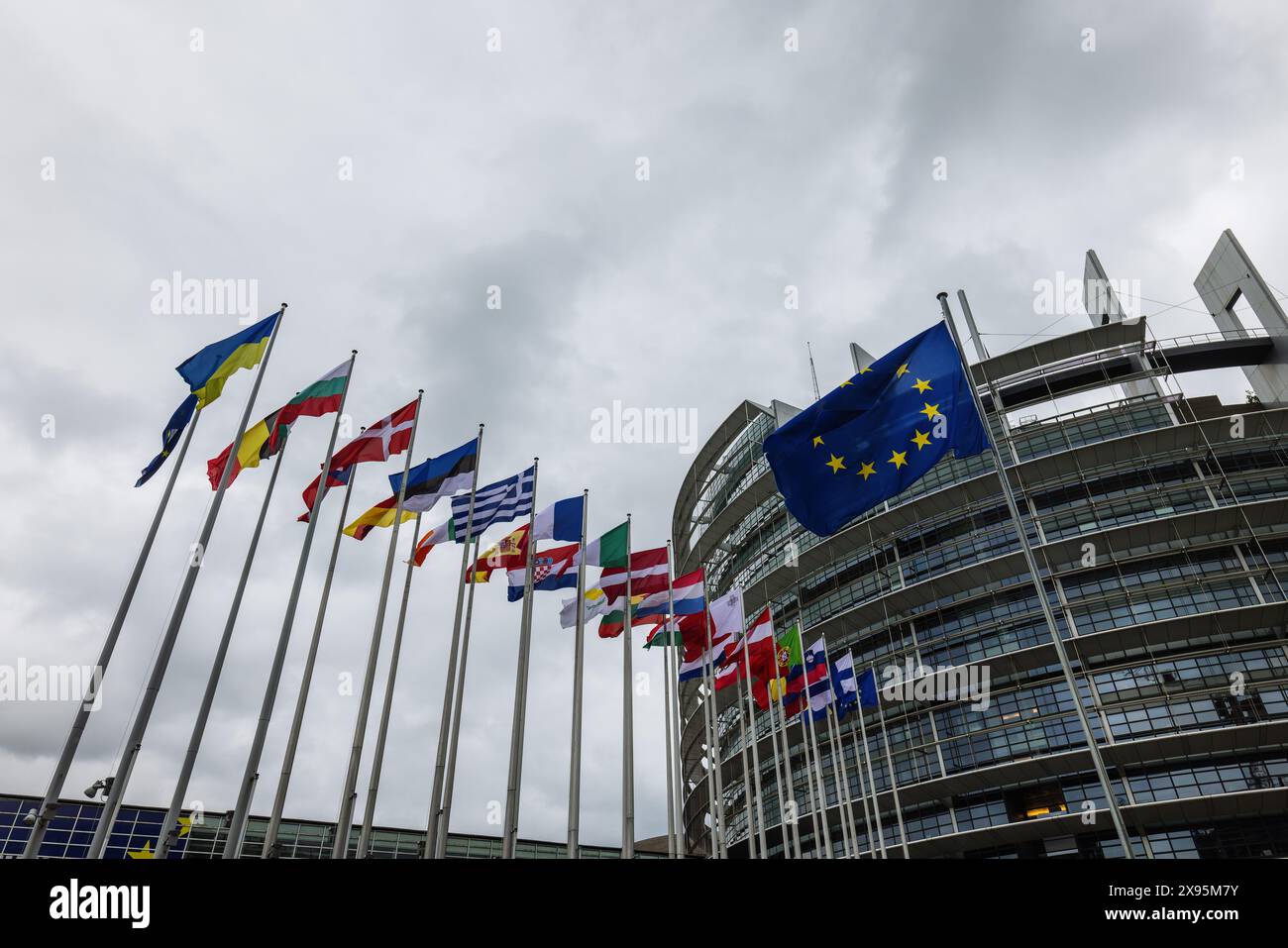 29 mai 2024, France, Straßburg : les drapeaux de l'Union européenne, de ses états membres et de l'Ukraine flottent devant le bâtiment du Parlement européen. Des fonctionnaires fouillent les bureaux du Parlement à Bruxelles et Strasbourg depuis ce matin. Les raids sont apparemment liés à l'affaire entourant le portail d'information pro-russe "voix de l'Europe", qui serait au centre d'une opération d'influence russe. Les élections européennes sont prévues pour le 9 juin. Photo : Philipp von Ditfurth/dpa Banque D'Images