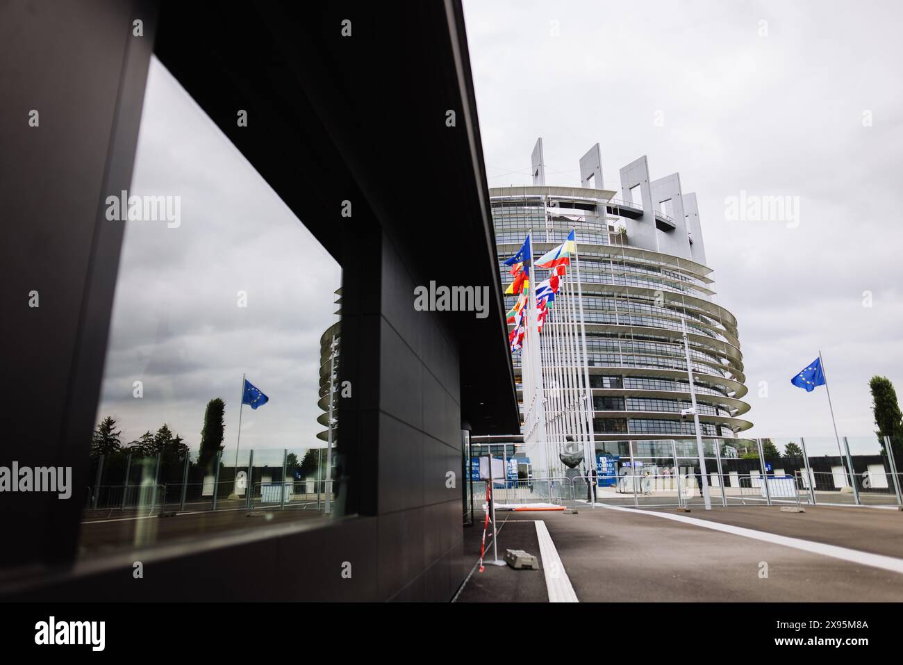 29 mai 2024, France, Straßburg : les drapeaux de l'Union européenne, de ses états membres et de l'Ukraine flottent devant le bâtiment du Parlement européen. Des fonctionnaires fouillent les bureaux du Parlement à Bruxelles et Strasbourg depuis ce matin. Les raids sont apparemment liés à l'affaire entourant le portail d'information pro-russe "voix de l'Europe", qui serait au centre d'une opération d'influence russe. Les élections européennes sont prévues pour le 9 juin. Photo : Philipp von Ditfurth/dpa Banque D'Images