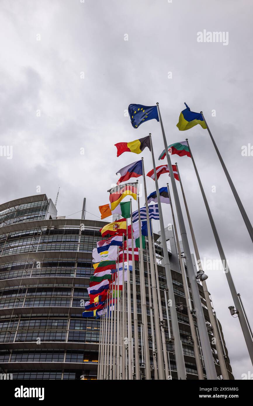 29 mai 2024, France, Straßburg : les drapeaux de l'Union européenne, de ses états membres et de l'Ukraine flottent devant le bâtiment du Parlement européen. Des fonctionnaires fouillent les bureaux du Parlement à Bruxelles et Strasbourg depuis ce matin. Les raids sont apparemment liés à l'affaire entourant le portail d'information pro-russe "voix de l'Europe", qui serait au centre d'une opération d'influence russe. Les élections européennes sont prévues pour le 9 juin. Photo : Philipp von Ditfurth/dpa Banque D'Images