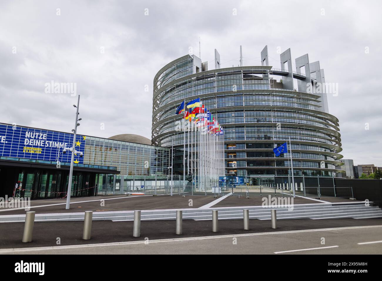 29 mai 2024, France, Straßburg : les drapeaux de l'Union européenne, de ses états membres et de l'Ukraine flottent devant le bâtiment du Parlement européen. Des fonctionnaires fouillent les bureaux du Parlement à Bruxelles et Strasbourg depuis ce matin. Les raids sont apparemment liés à l'affaire entourant le portail d'information pro-russe "voix de l'Europe", qui serait au centre d'une opération d'influence russe. Les élections européennes sont prévues pour le 9 juin. Photo : Philipp von Ditfurth/dpa Banque D'Images