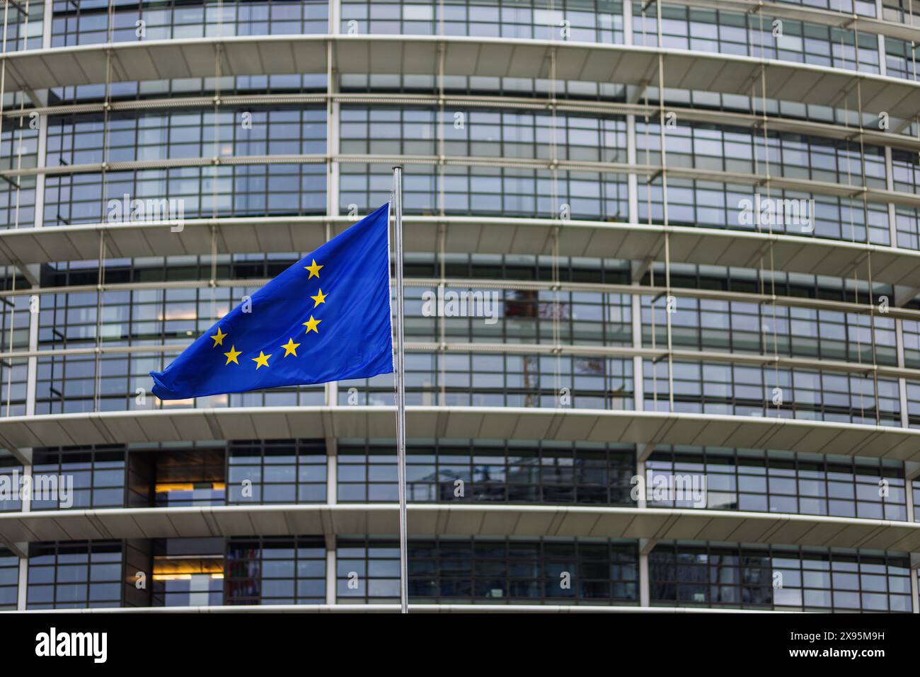29 mai 2024, France, Straßburg : le drapeau de l'Union européenne flotte au vent devant le bâtiment du Parlement européen. Des fonctionnaires fouillent les bureaux du Parlement à Bruxelles et Strasbourg depuis ce matin. Les raids sont apparemment liés à l'affaire entourant le portail d'information pro-russe "voix de l'Europe", qui serait au centre d'une opération d'influence russe. Les élections européennes sont prévues pour le 9 juin. Photo : Philipp von Ditfurth/dpa Banque D'Images