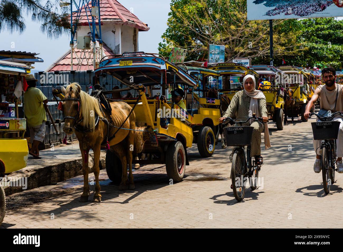 Des charrettes à chevaux traditionnelles (Cidomo) attendent à côté du port sur la rue principale de l'île Gili Trawangan à In Banque D'Images