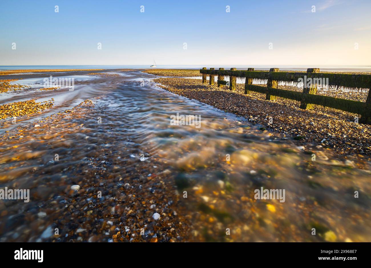 Un bateau au large de la plage de Cuckmere Haven au coucher du soleil, East Sussex, Angleterre, Royaume-Uni, Europe Banque D'Images