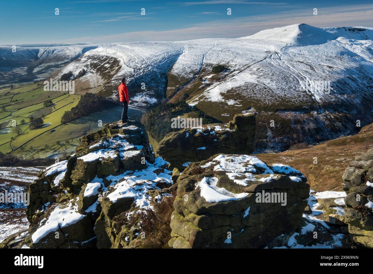 Walker surplombe Grindslow Knoll et la vallée de l'Edale depuis la formation rocheuse de Ringing Roger en hiver, Kinder Scout, Peak District National Park, Der Banque D'Images