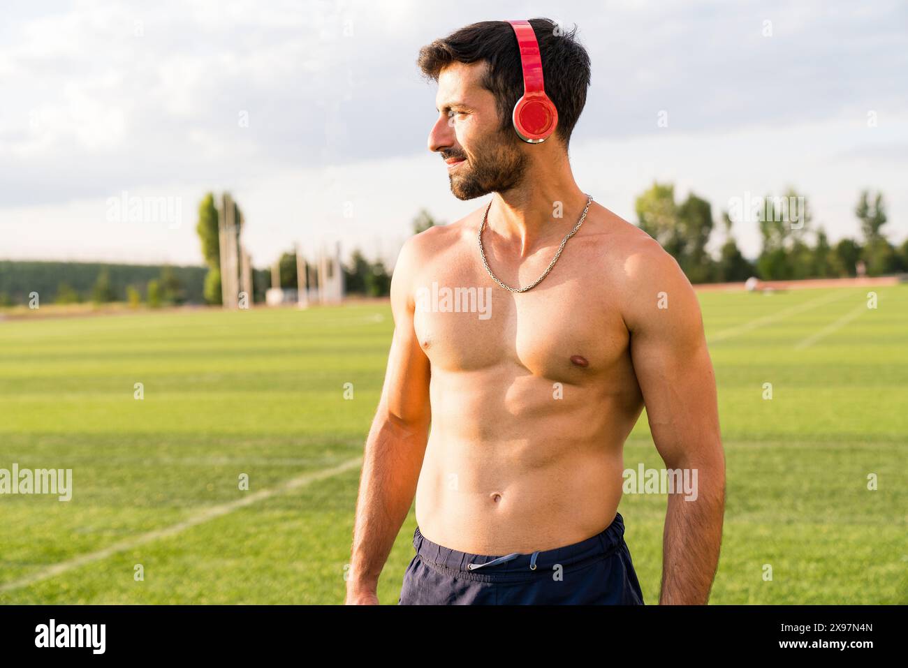 Homme athlète écoutant de la musique avec des écouteurs. homme faisant du sport dehors écoutant de la musique Banque D'Images
