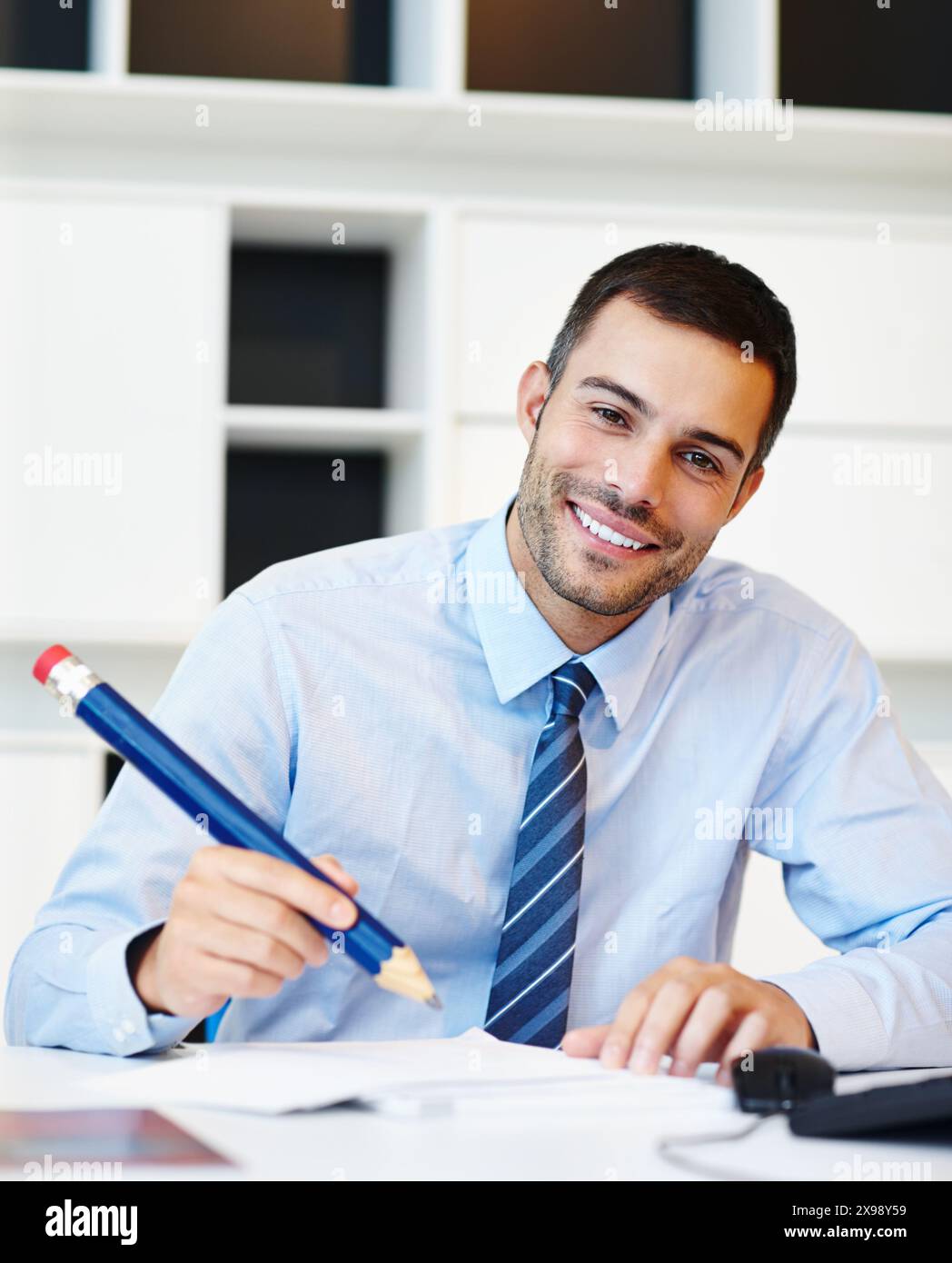 Crayon, portrait et sourire avec homme d'affaires au bureau dans le bureau pour la planification, le rapport ou l'écriture. Ordre du jour, prop et horaire avec employé heureux dans Banque D'Images