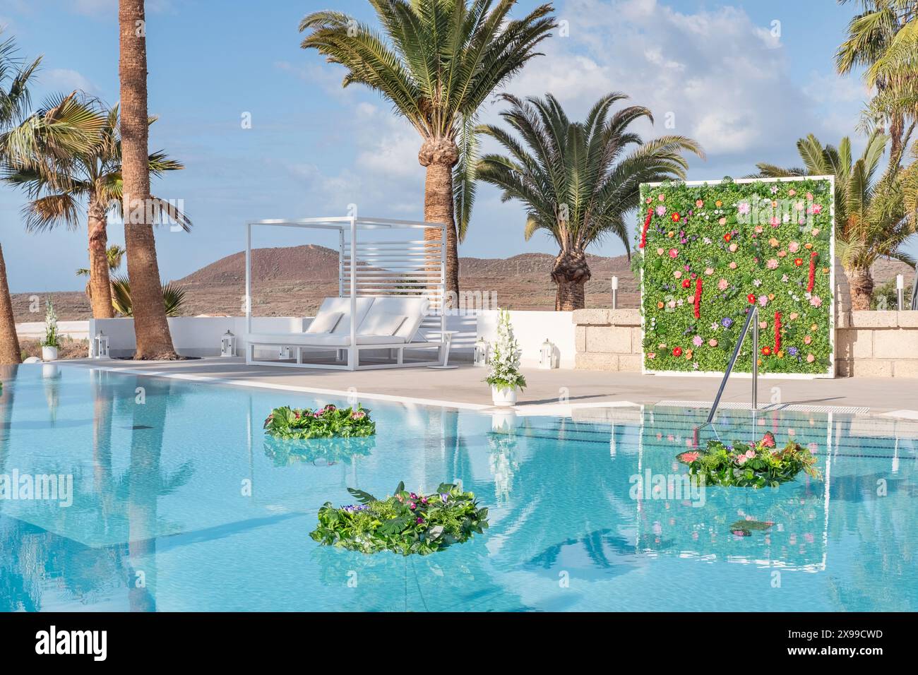 Espace piscine joliment décoré préparé pour un mariage hindou ou un événement festif avec des bouquets de fleurs flottantes de feuilles vertes luxuriantes et de fleurs Banque D'Images