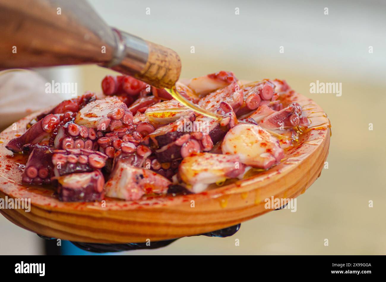 Huile d'olive sur une portion de poulpe, préparée dans le style traditionnel Pulpo a feira. Galice, Espagne Banque D'Images