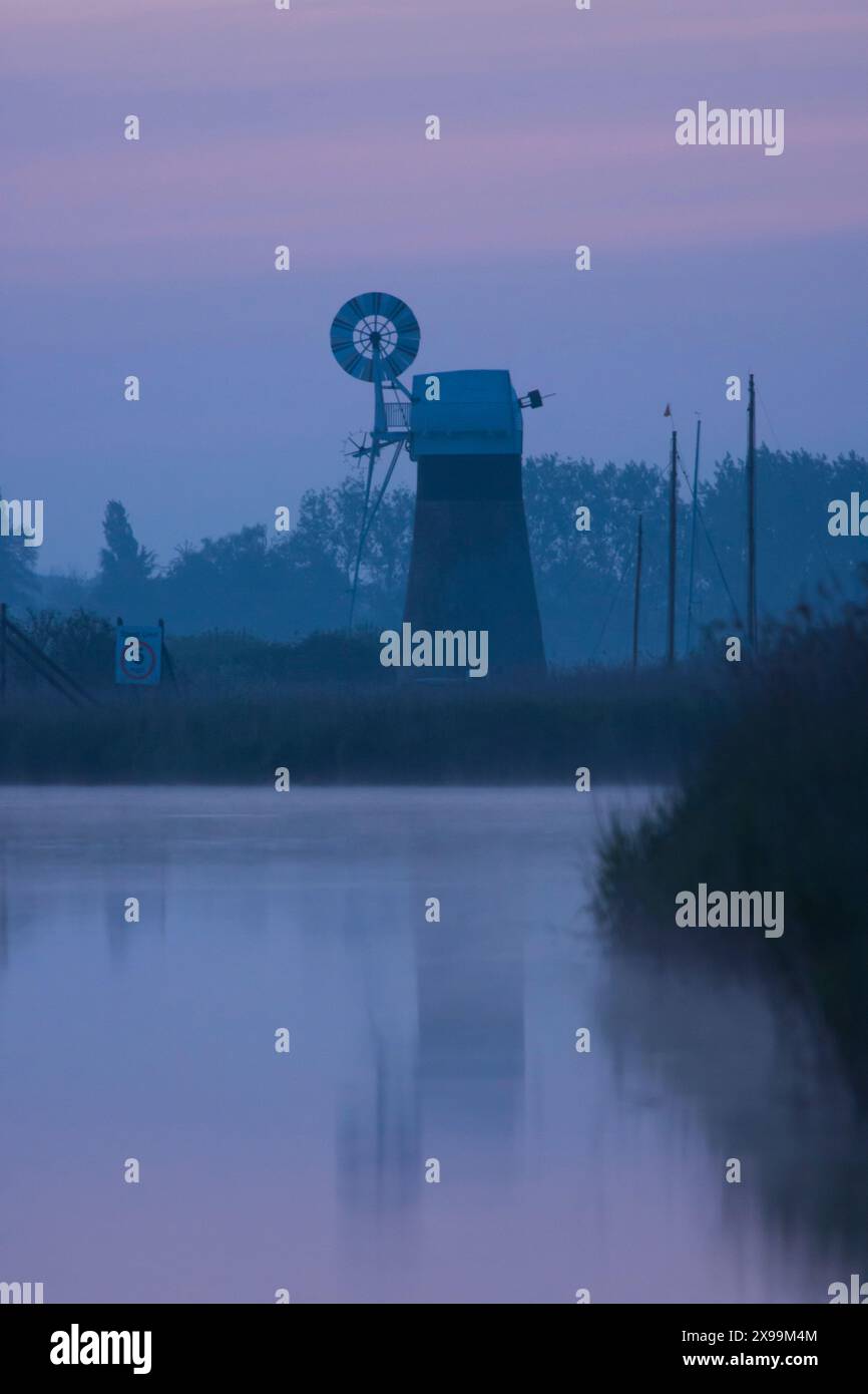 Usine de drainage de niveau de St Benet, brume bleue au crépuscule, vue de la rivière Bure, Banque D'Images