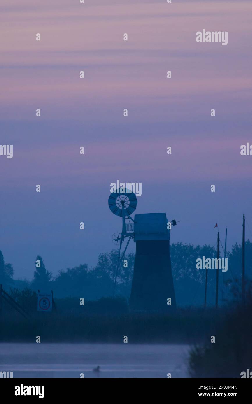 Usine de drainage de niveau de St Benet, brume bleue au crépuscule, vue de la rivière Bure, Banque D'Images