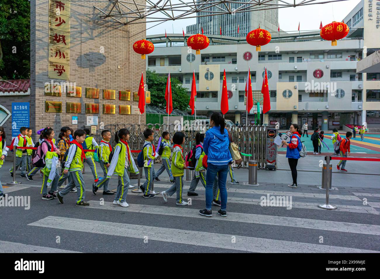 Chengdu, Chine, Sichuan, les gens de foule, les enfants chinois, uniformes se rendant à l'école avec instructeur dans la rue Banque D'Images