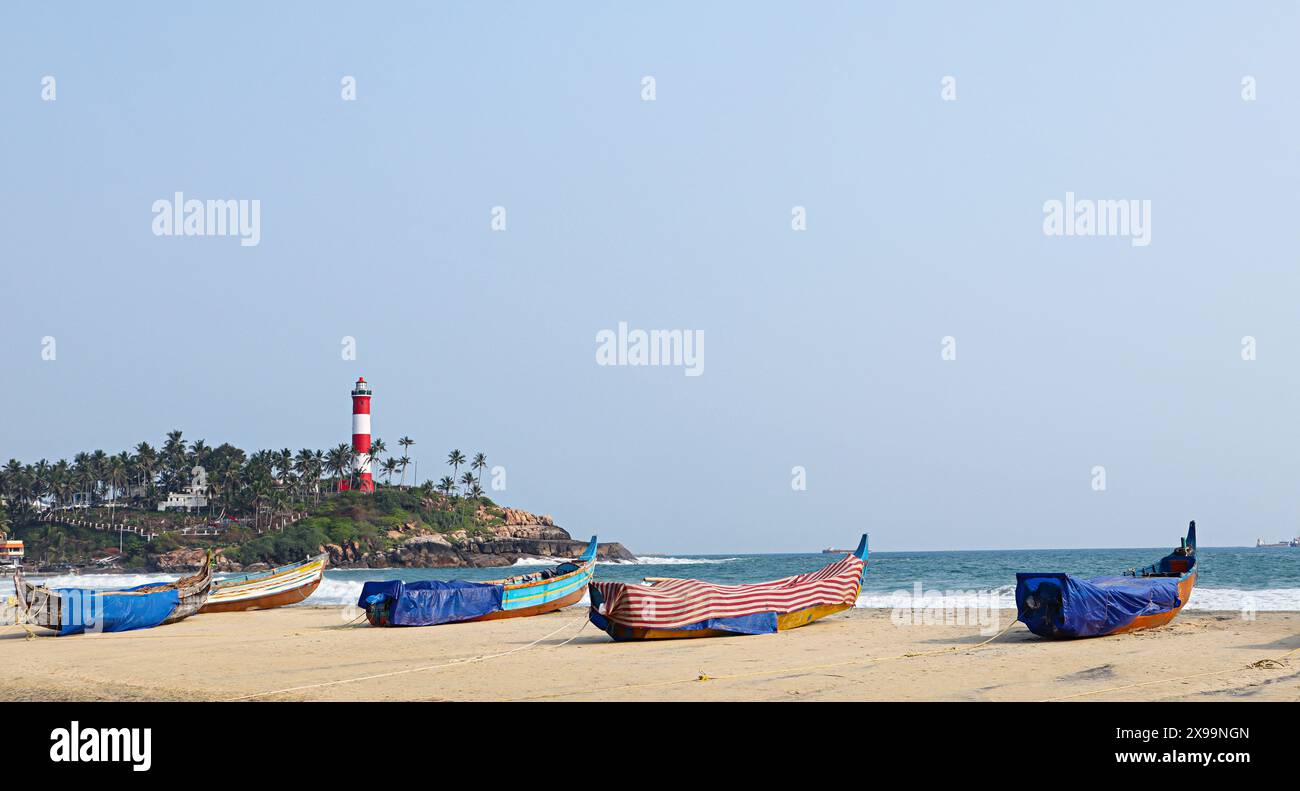 Bateaux de mer et phare à Kovalam Beach, Thiruvananthapuram, Kerala, Inde. Banque D'Images