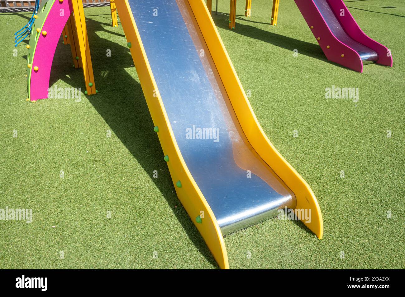 détail d'une glissière en métal et en plastique dans une aire de jeux pour enfants Banque D'Images