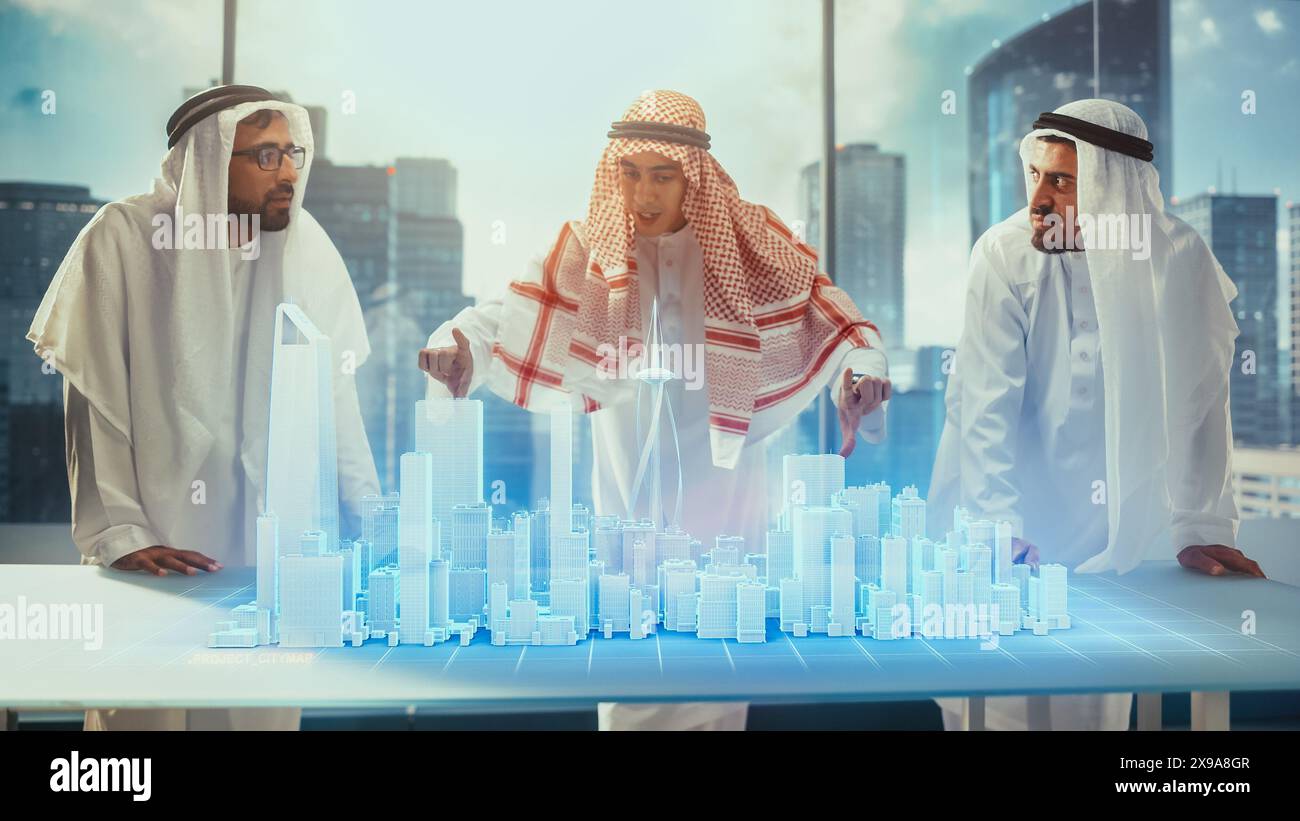 Groupe de développeurs d'affaires immobilières arabes dans les vêtements traditionnels discutent des opportunités d'investissement basées sur le modèle de ville 3D de réalité augmentée holographique dans leur bureau moderne dans un gratte-ciel. Banque D'Images