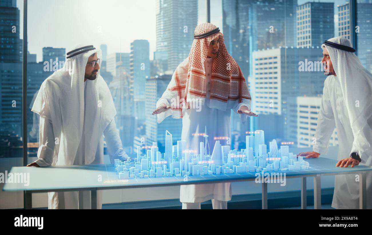Groupe de développeurs d'affaires immobilières musulmanes en vêtements traditionnels discutent des opportunités d'investissement basées sur le modèle de ville 3D de réalité augmentée holographique dans leur bureau moderne dans un gratte-ciel. Banque D'Images