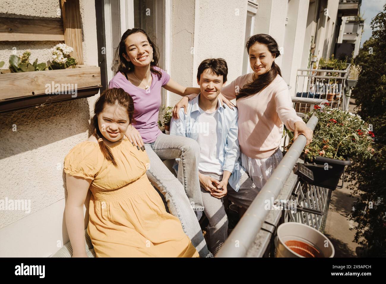 Portrait de mère avec enfants en balcon à la journée ensoleillée Banque D'Images