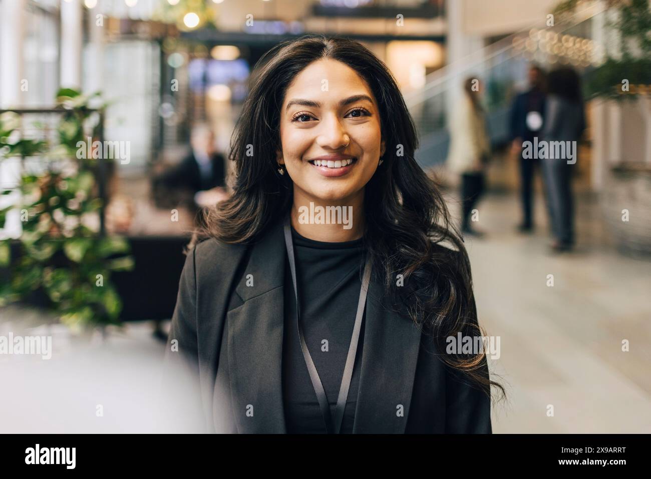Portrait de jeune femme d'affaires heureuse debout à l'événement de réseautage dans le centre de congrès Banque D'Images
