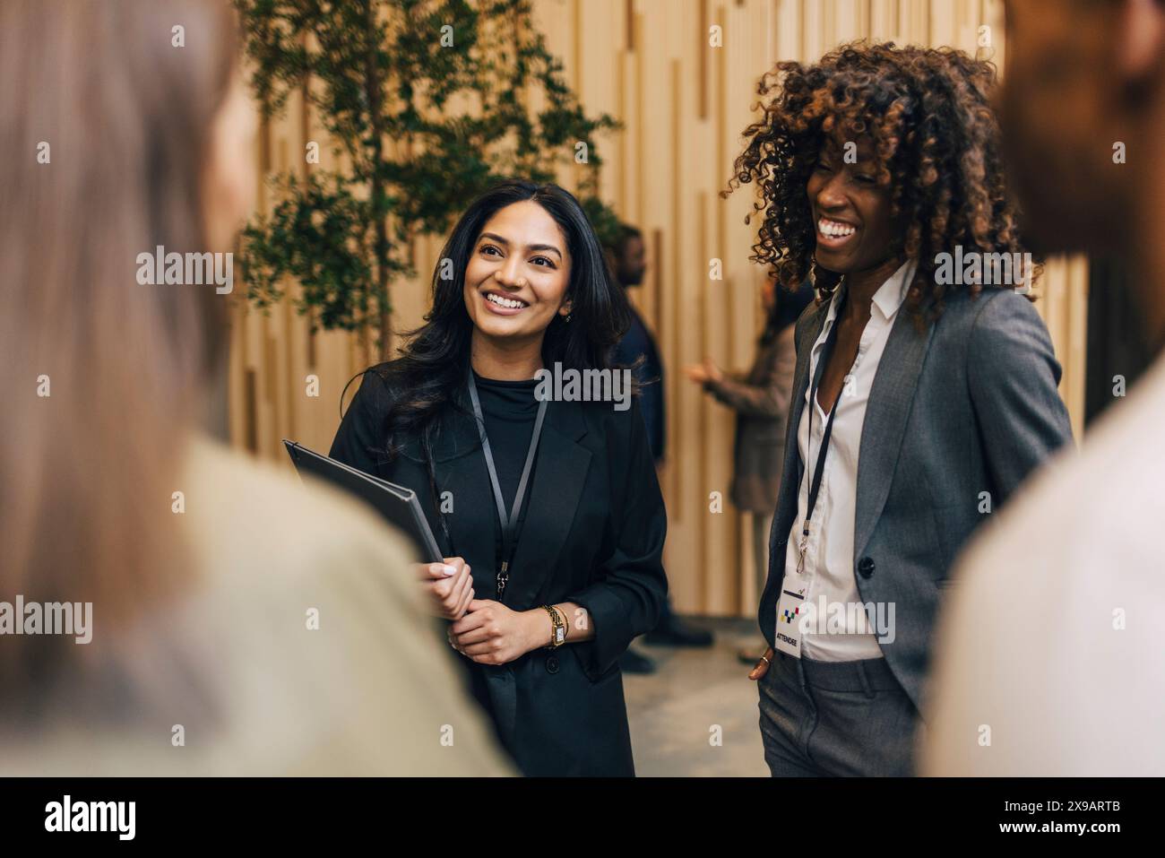 Heureuses entrepreneures discutant avec les délégués lors de l'événement de réseautage au centre des congrès Banque D'Images