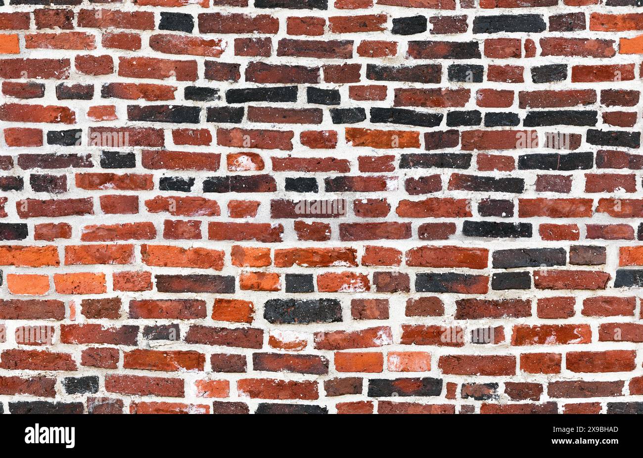 Ancien mur de briques avec des briques rouges et noires et du béton blanc, texture de photo de fond sans couture Banque D'Images