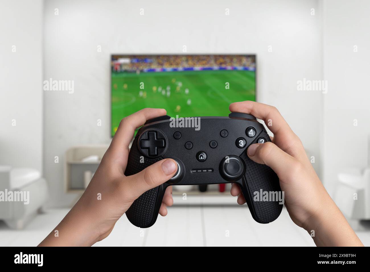 Mains tenant une manette de jeu, jouant un match de football sur un grand écran de télévision. Parfait pour le jeu, le sport et le concept de divertissement Banque D'Images