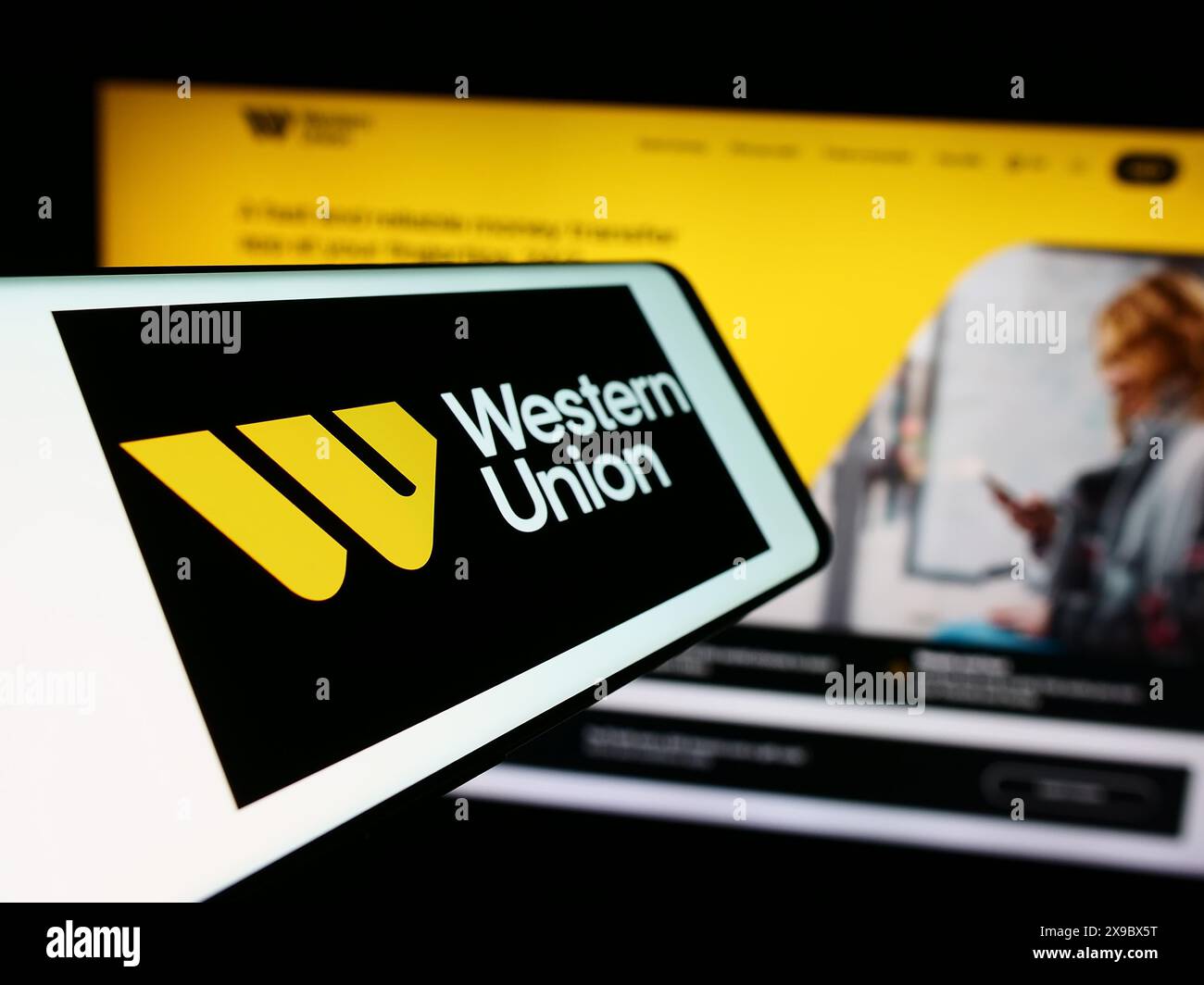 Smartphone avec le logo de la société de services financiers américaine Western Union Company devant le site Web. Mettez l'accent sur le centre-gauche de l'écran du téléphone. Banque D'Images