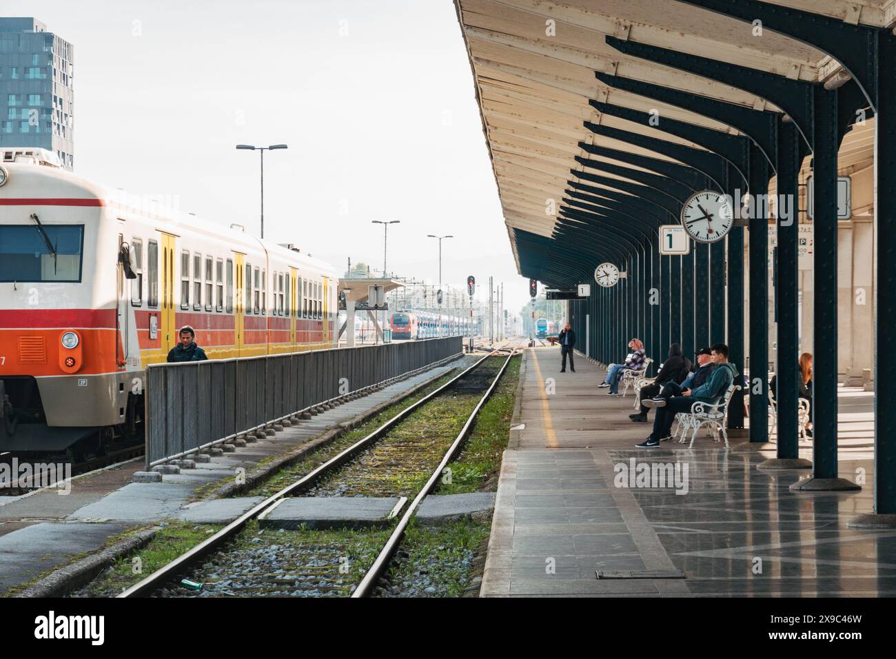 Un train de voyageurs de style ancien à la gare de Ljubljana, Slovénie. Les gens attendent sur des sièges sur le quai Banque D'Images