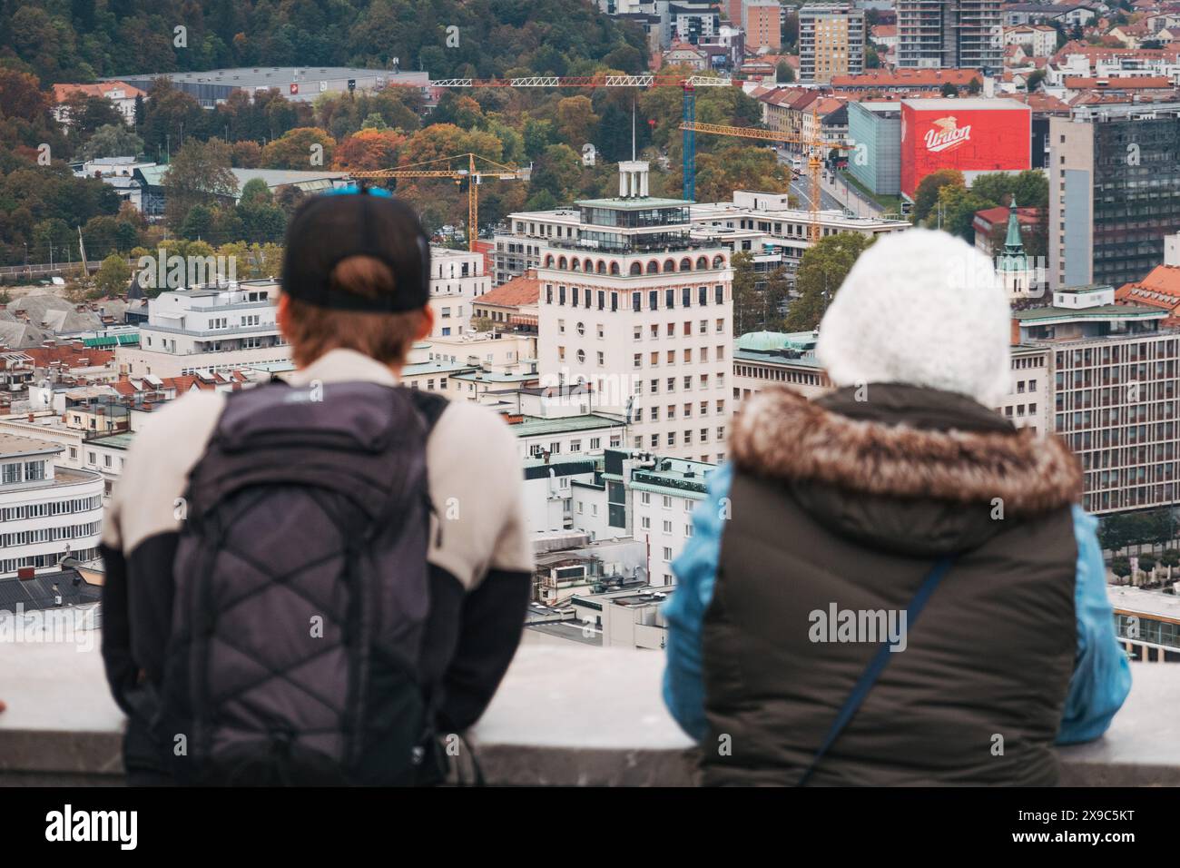 Les touristes se tiennent au sommet d'une tour de guet au château de Ljubljana, Slovénie, regardant la ville, par temps nuageux Banque D'Images