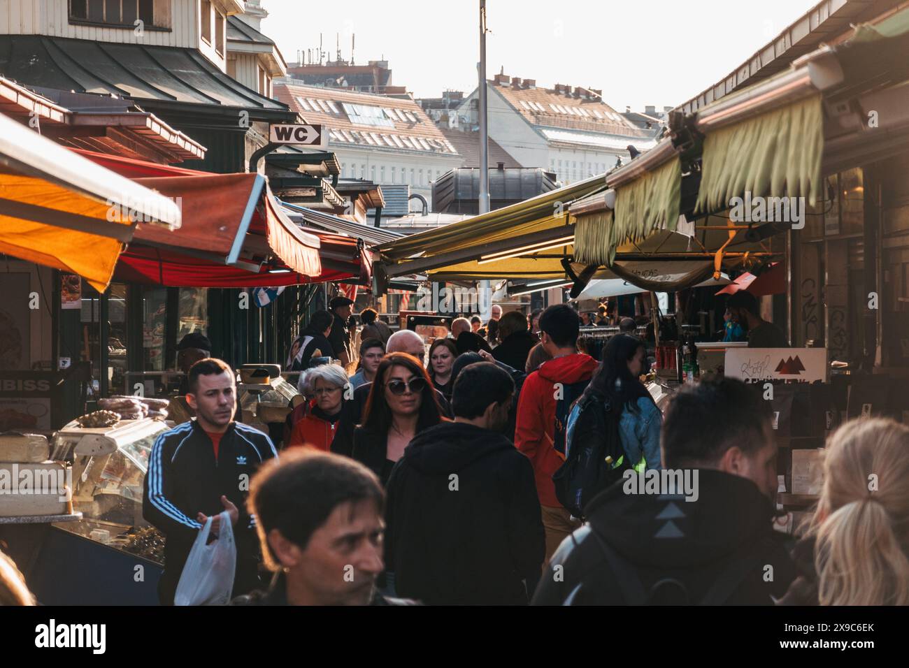 Les acheteurs parcourent les différents stands du Naschmarkt, un marché en plein air de Vienne, en Autriche, par un après-midi d'automne ensoleillé Banque D'Images