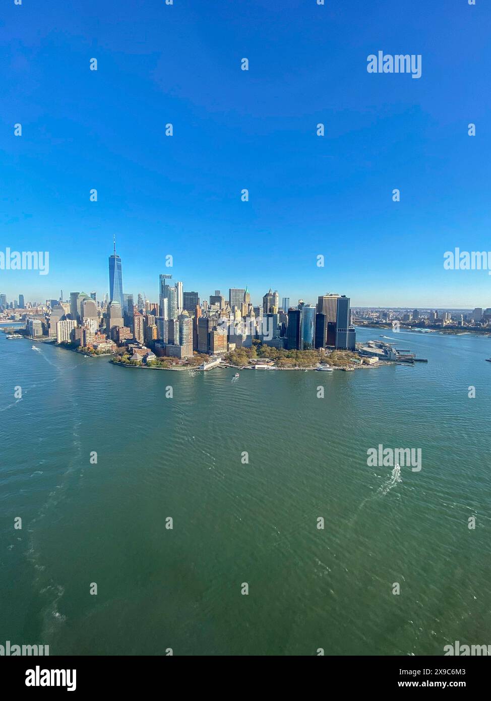 Vue sur la ville d'une île avec des gratte-ciels et de l'eau sous un ciel bleu, la ligne d'horizon de New york avec des gratte-ciels impressionnants sur la rivière hudson, nouveau Banque D'Images