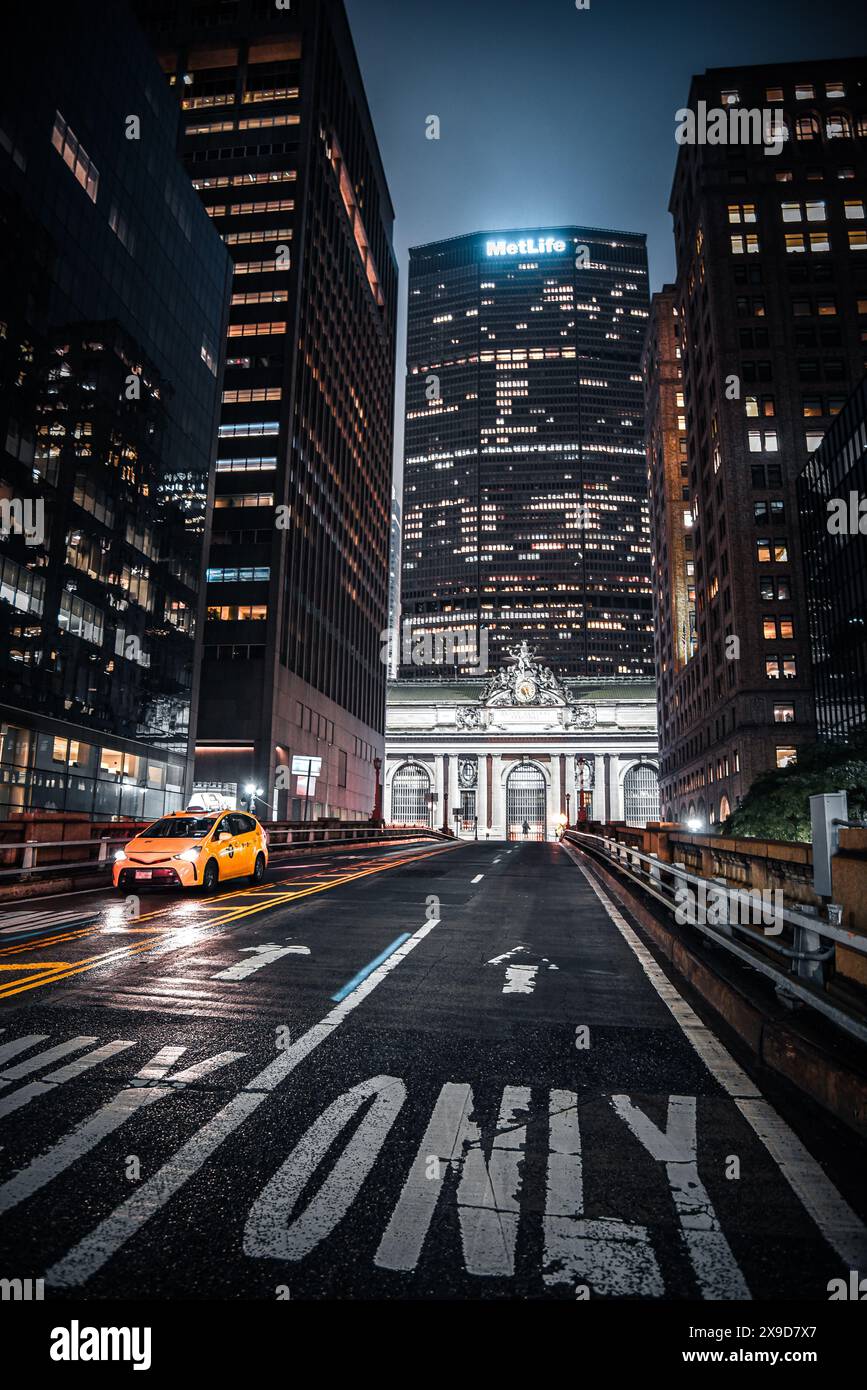 Un taxi jaune conduisant sur Park Ave Viaduc, avec le Grand Central terminal et le MetLife Building en arrière-plan - Manhattan, New York City Banque D'Images