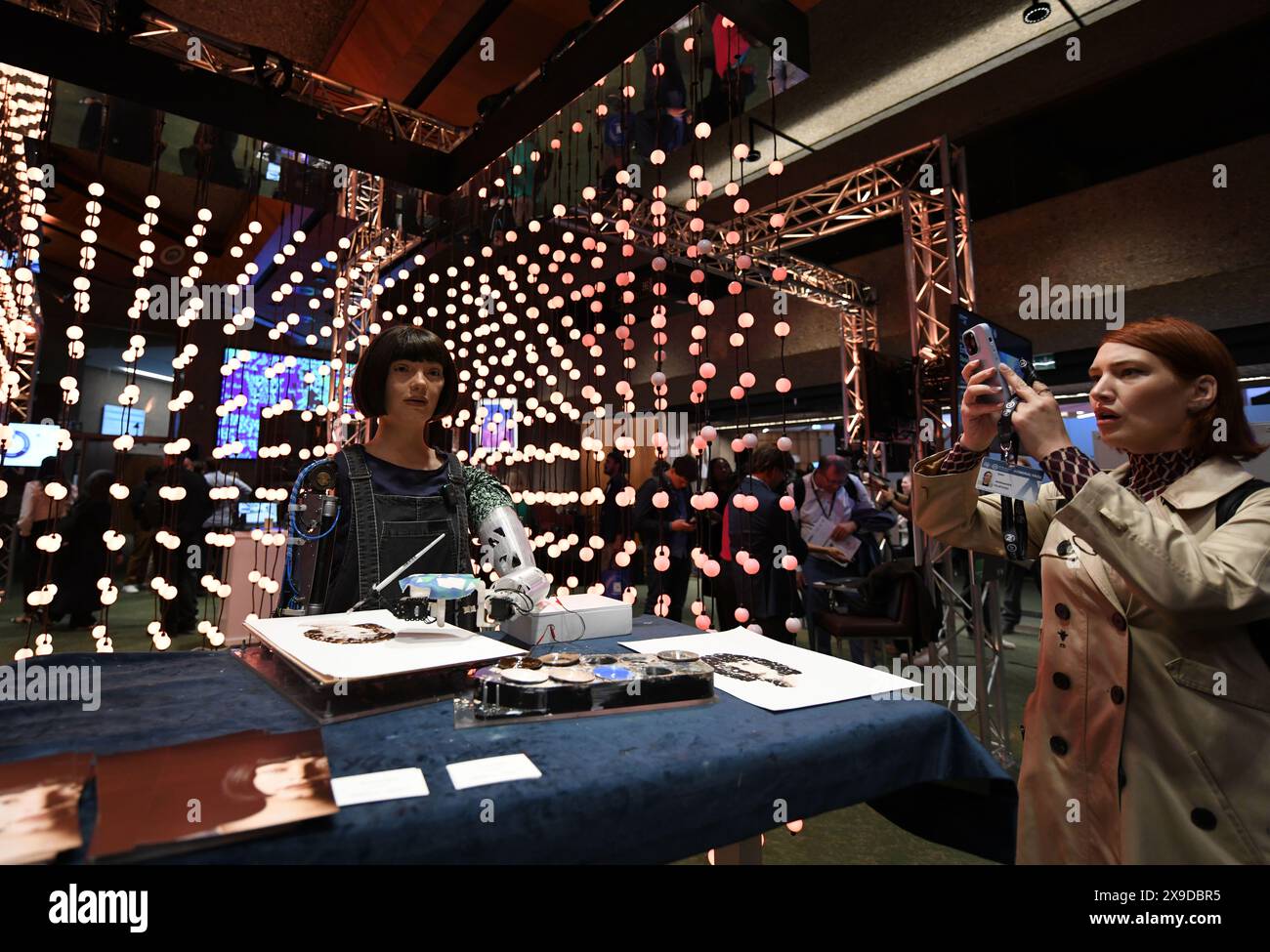 Genève, Suisse. 30 mai 2024. Un participant prend des photos de l’artiste robot ai-Da au Sommet mondial 2024 de l’Intelligence artificielle (ai) pour une bonne intelligence à Genève, en Suisse, le 30 mai 2024. Le 2024 Sommet mondial de l’Intelligence artificielle (IA) pour une bonne intelligence a débuté jeudi dans la capitale suisse, Genève. Crédit : Lian Yi/Xinhua/Alamy Live News Banque D'Images