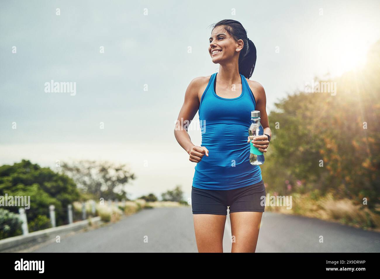 Penser, coureur ou femme heureuse boire de l'eau sur la pause pour hydrater ou se détendre pour une énergie saine dans l'exercice. Fitness, sourire et athlète assoiffé avec Banque D'Images