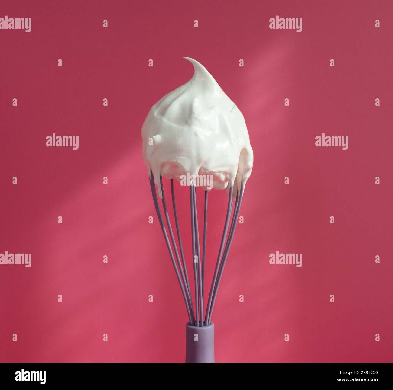 meringue fouettée sur un blanc sur un fond rose Banque D'Images