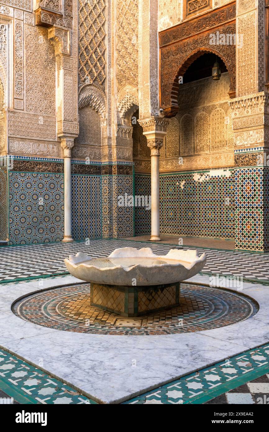 Fès, Maroc - 4 mars 2024 : fontaine et cour dans l'école de parfumeurs Al-Attarine Madrasa dans le centre-ville de Fès Banque D'Images