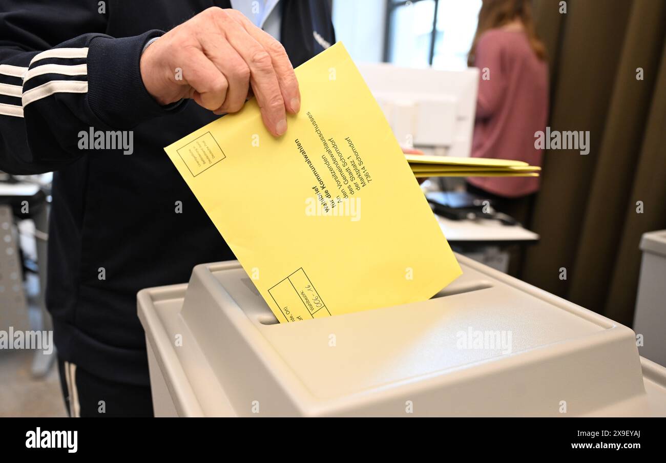 Schorndorf, Allemagne. 31 mai 2024. Une lettre de vote avec un bulletin de vote pour l'élection municipale est placée dans une urne à un bureau de vote de l'hôtel de ville pour le vote par correspondance. Crédit : Bernd Weißbrod/dpa/Alamy Live News Banque D'Images