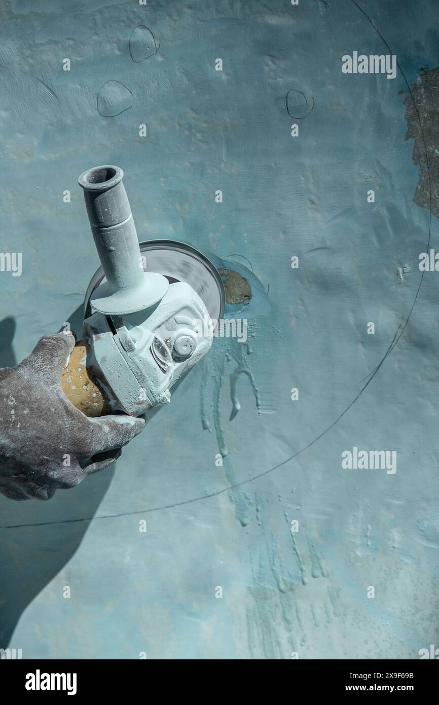 L'eau piégée s'échappe lors du broyage des bulles dans la vieille fibre de verre. Banque D'Images