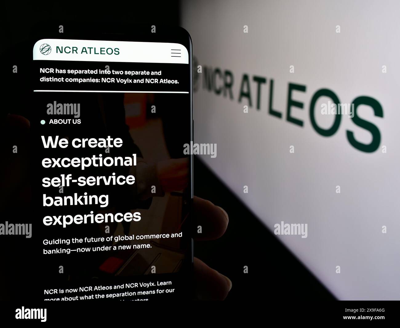 Personne tenant le téléphone portable avec la page Web de la société américaine de services financiers NCR Atleos Corporation devant le logo. Concentrez-vous sur le centre de l'écran du téléphone. Banque D'Images