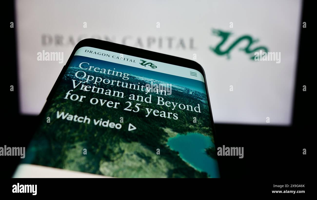 Téléphone portable avec le site Web de la société vietnamienne Dragon Capital Group Limited devant le logo de l'entreprise. Concentrez-vous sur le coin supérieur gauche de l'écran du téléphone. Banque D'Images