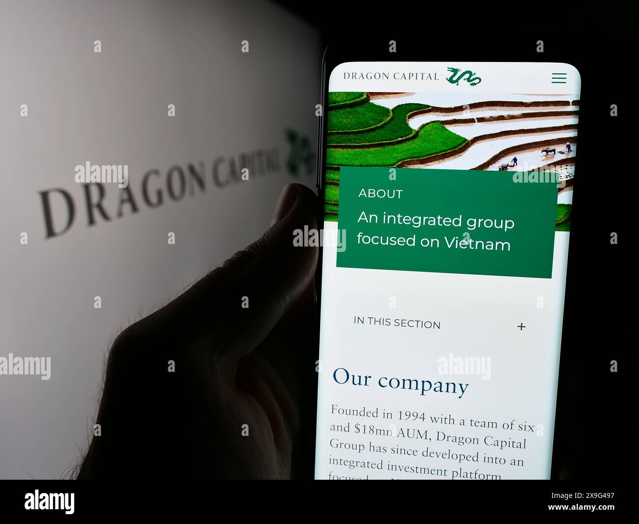 Personne tenant smartphone avec la page Web de la société vietnamienne Dragon Capital Group Limited devant le logo. Concentrez-vous sur le centre de l'écran du téléphone. Banque D'Images