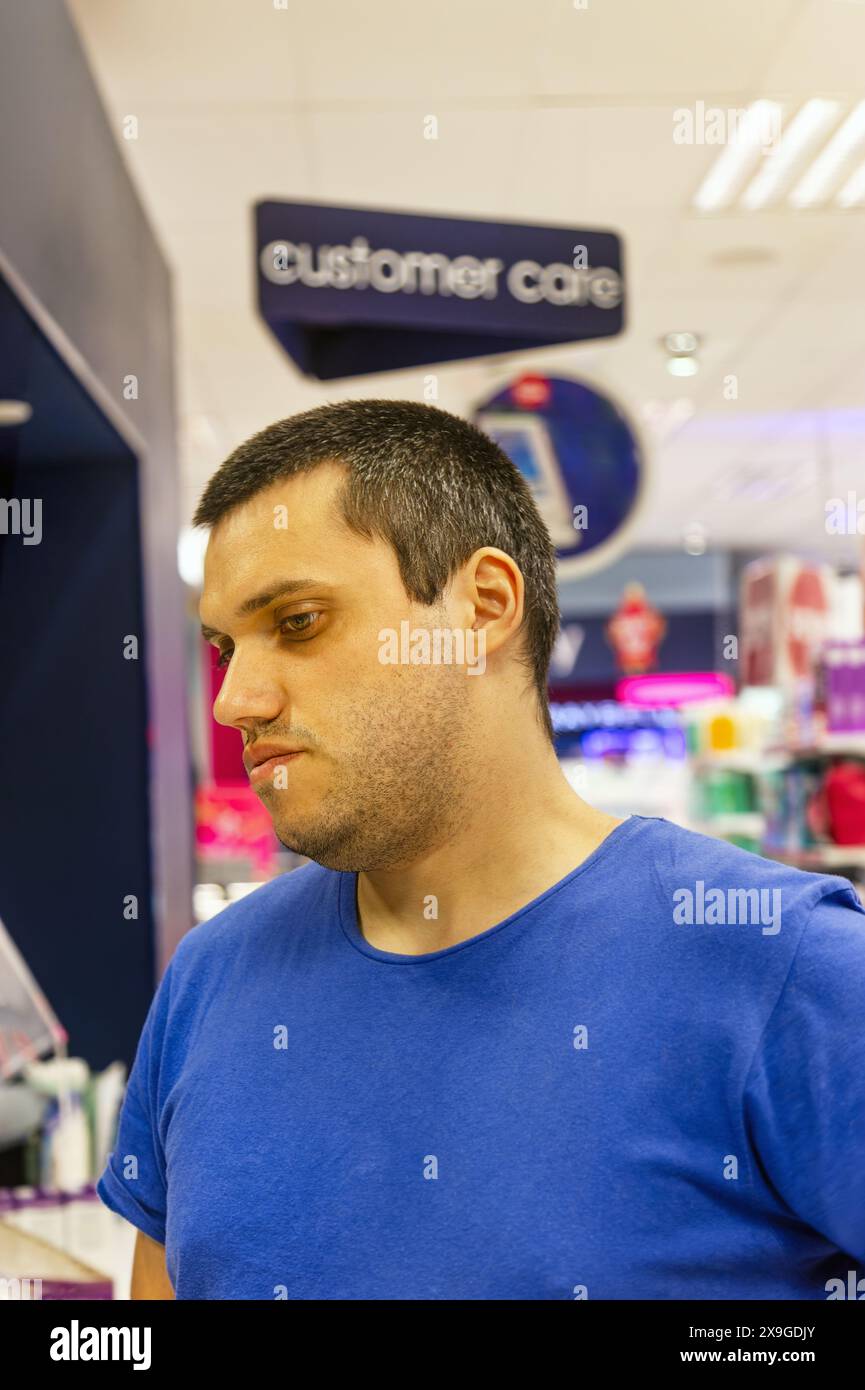magasinez l'homme du comptoir du service à la clientèle dans le repère attendant ses marchandises Banque D'Images