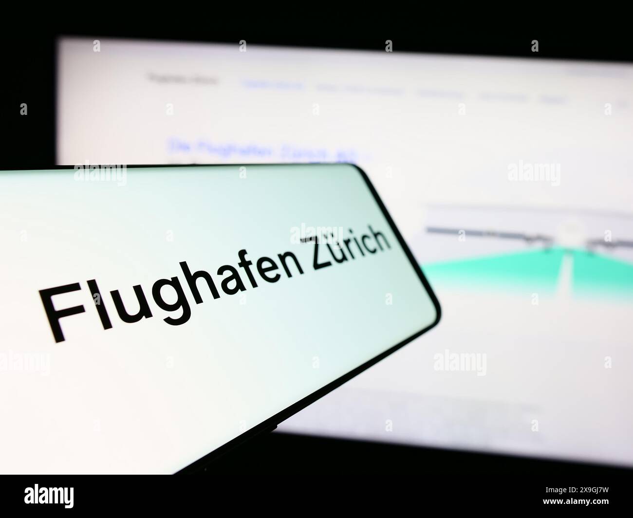 Téléphone portable avec le logo de la compagnie aéroportuaire suisse Flughafen Zürich AG (FZAG) en face du site. Mettez l'accent sur le centre-gauche de l'écran du téléphone. Banque D'Images