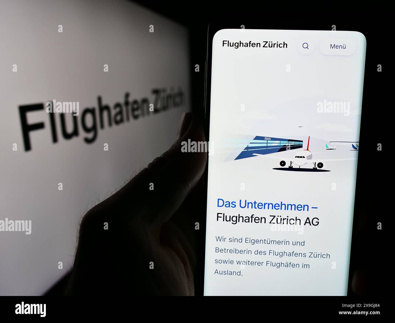 Personne détenant un smartphone avec le site web de la compagnie aéroportuaire suisse Flughafen Zürich AG (FZAG) avec logo. Concentrez-vous sur le centre de l'écran du téléphone. Banque D'Images