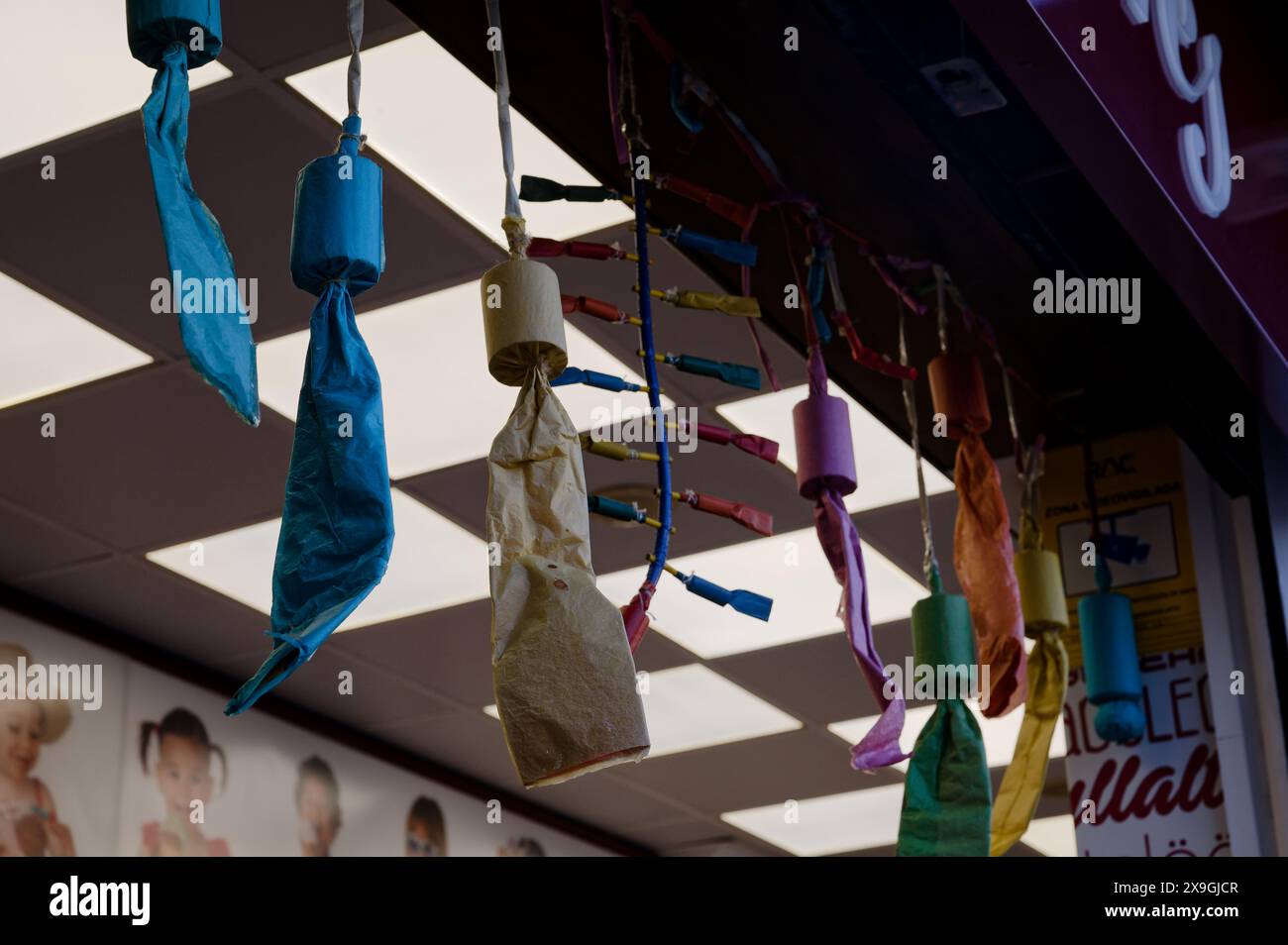 Décorations en papier colorées accrochées à l'extérieur d'un magasin de crème glacée à Valence, ajoutant à l'esprit festif du festival las fallas Banque D'Images