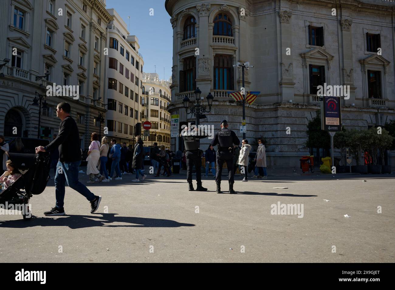 Les policiers regardent les gens marcher dans une rue animée de Valence, pendant les festivités de las fallas Banque D'Images