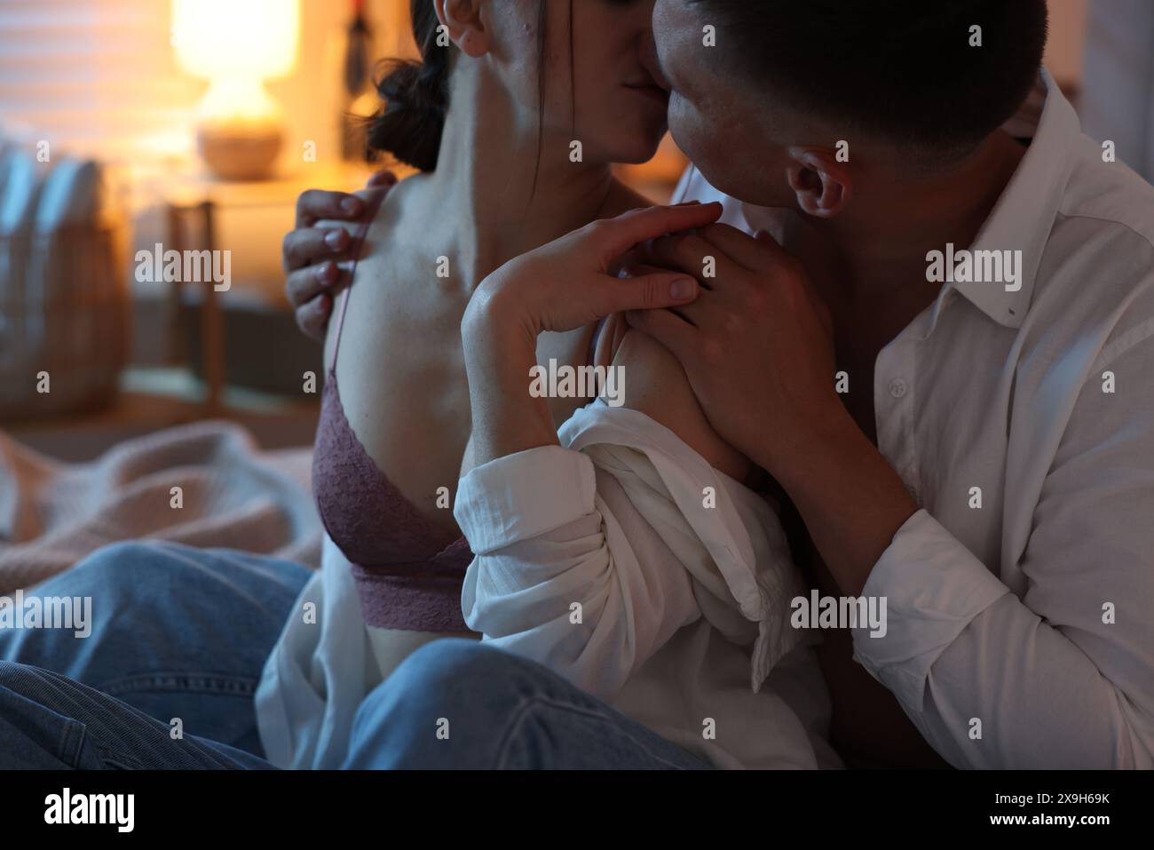 Couple passionné s'embrassant dans la chambre la nuit, gros plan Banque D'Images