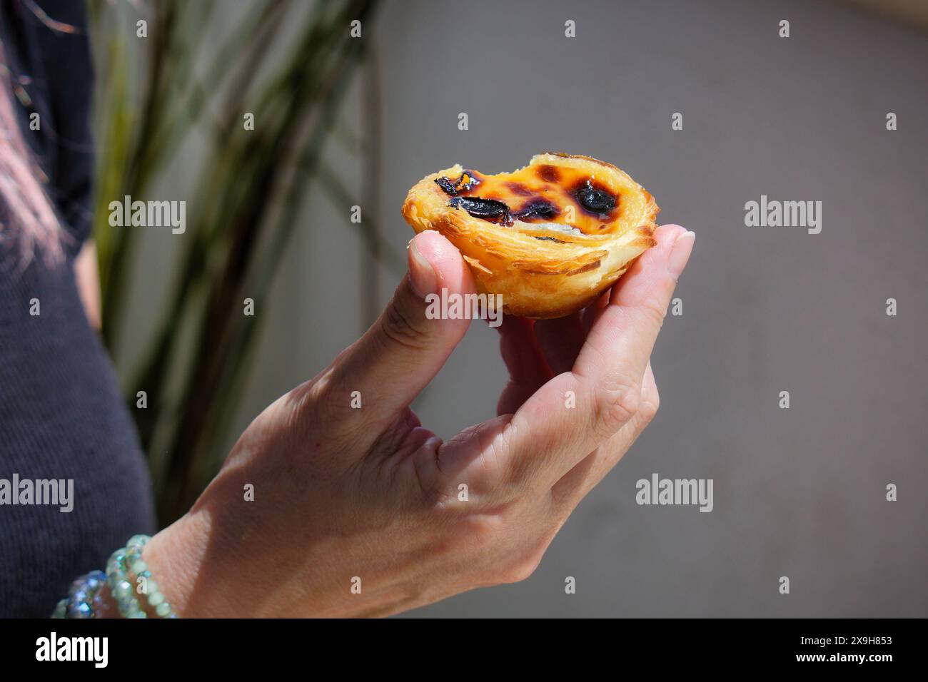 une femme tient dans sa main un délicieux pastéis de nata de lisbonne Banque D'Images