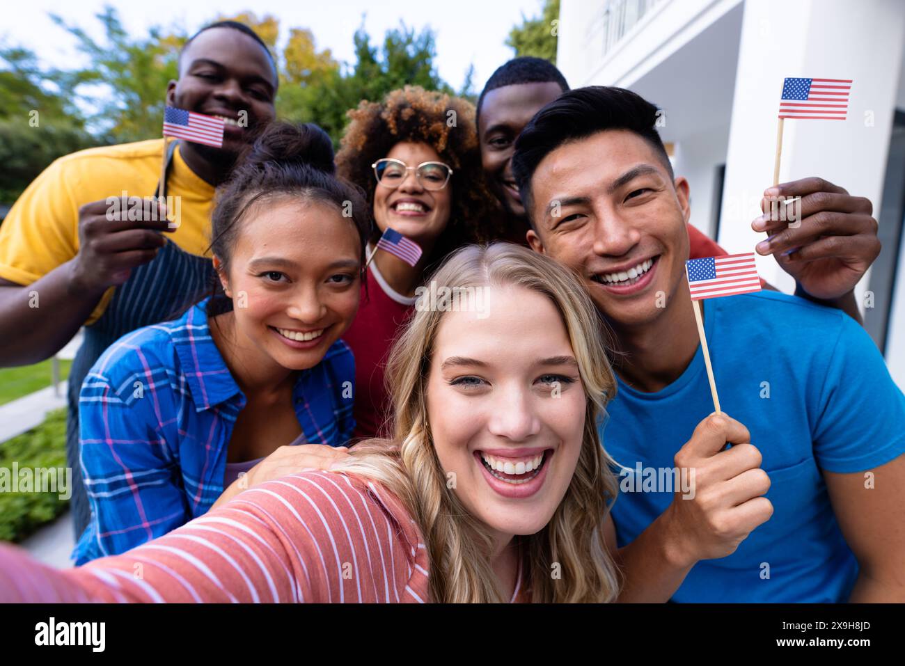Portrait d'heureux groupe diversifié d'amis prenant selfie et tenant des drapeaux des états-unis Banque D'Images