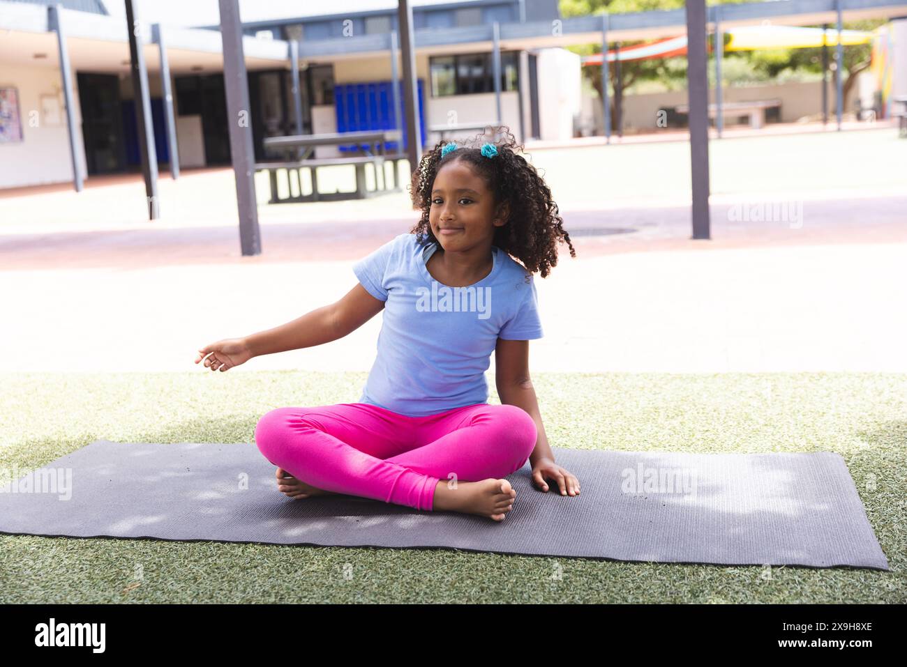 Une fille biraciale pratique le yoga à l'école, avec un espace de copie Banque D'Images