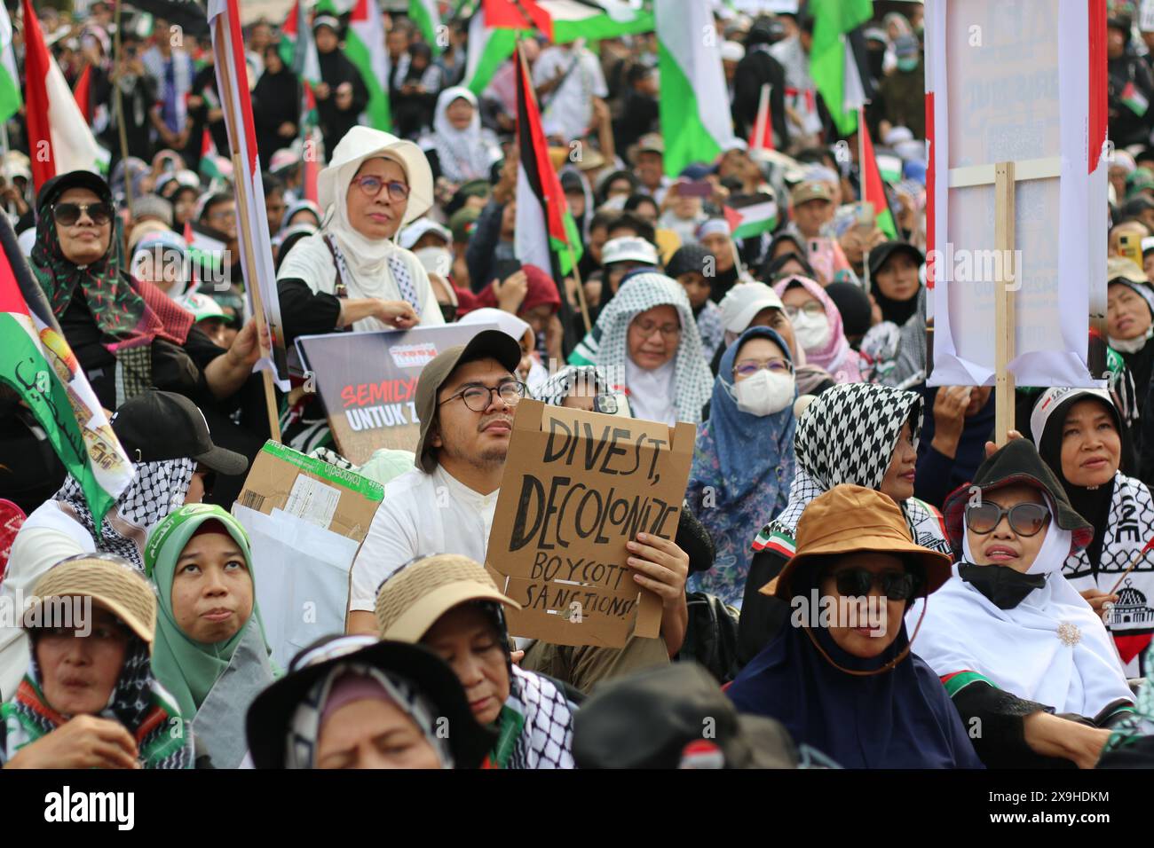 JAKARTA, INDONÉSIE - 1er JUIN : un manifestant pro-palestinien brandit une pancarte indiquant "Désinvestir, décoloniser, boycotter et sanctions" lors d'une manifestation pro-palestinienne devant l'ambassade américaine à Jakarta, en Indonésie, le 1er juin 2024. La manifestation a protesté contre l'attaque militaire israélienne contre Rafah, Gaza. Banque D'Images