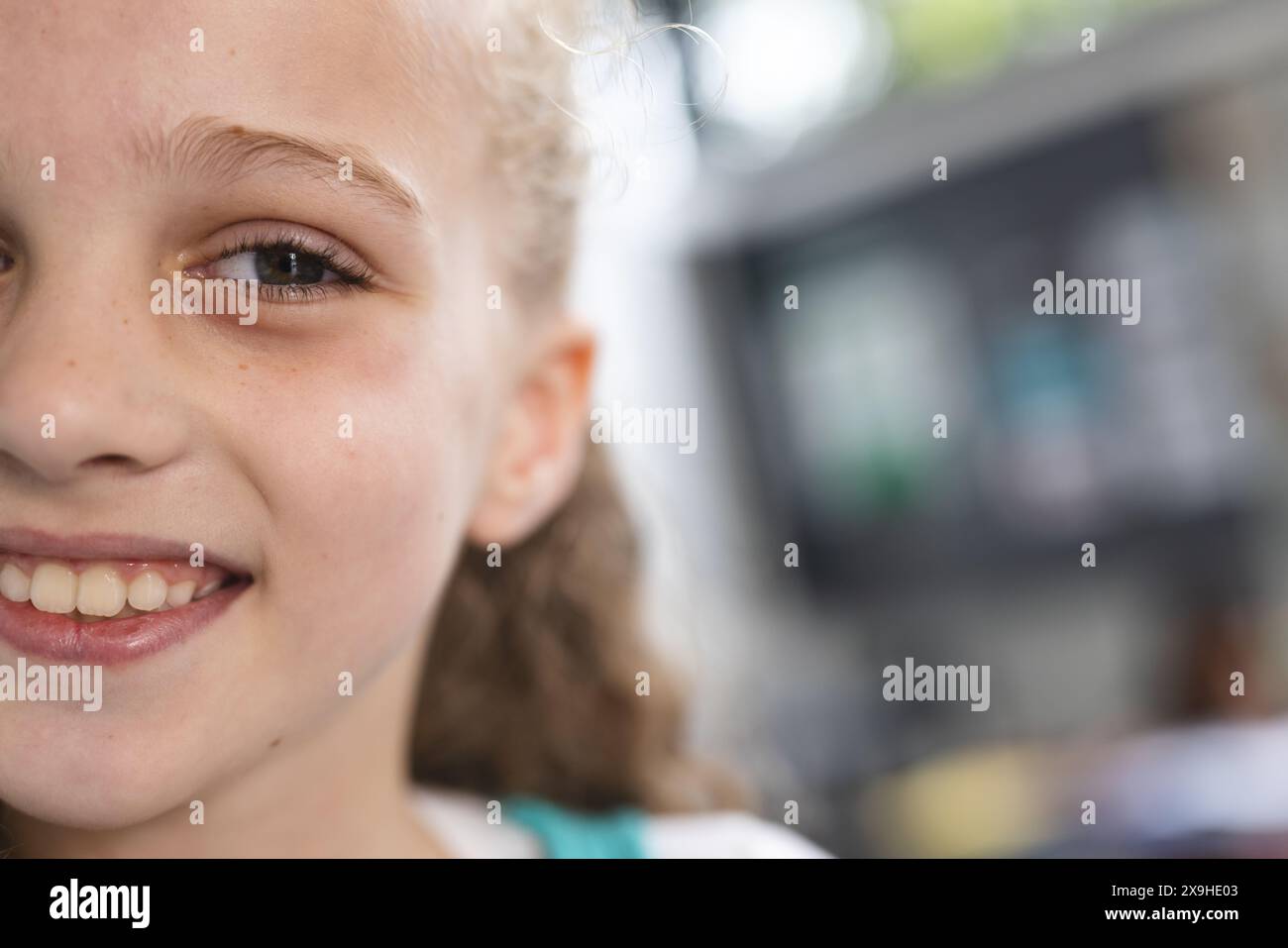À l'école, la jeune fille caucasienne sourit avec un espace de copie dans la salle de classe Banque D'Images